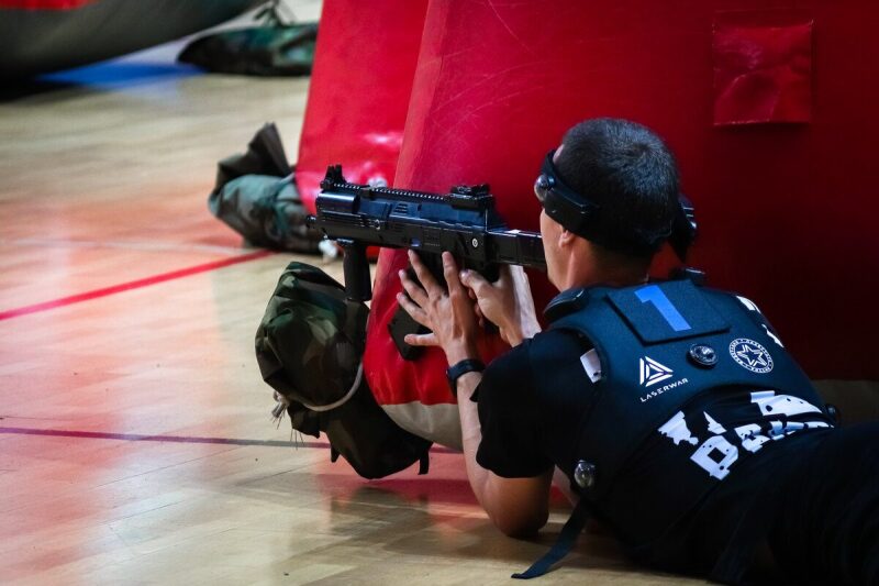 Боец LASERWAR в лежачей позиции с оружием наготове.